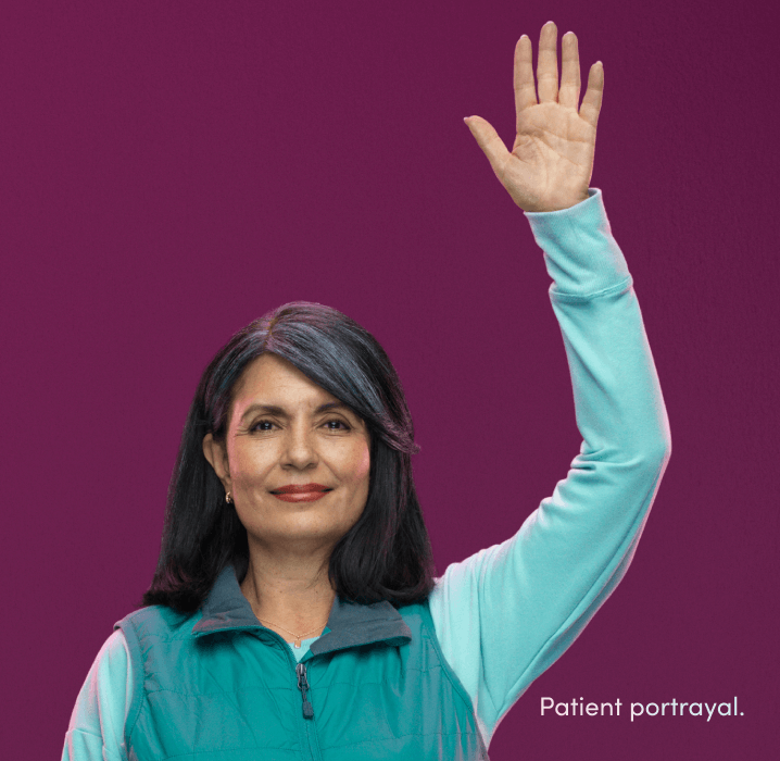 A woman standing with her hand raised